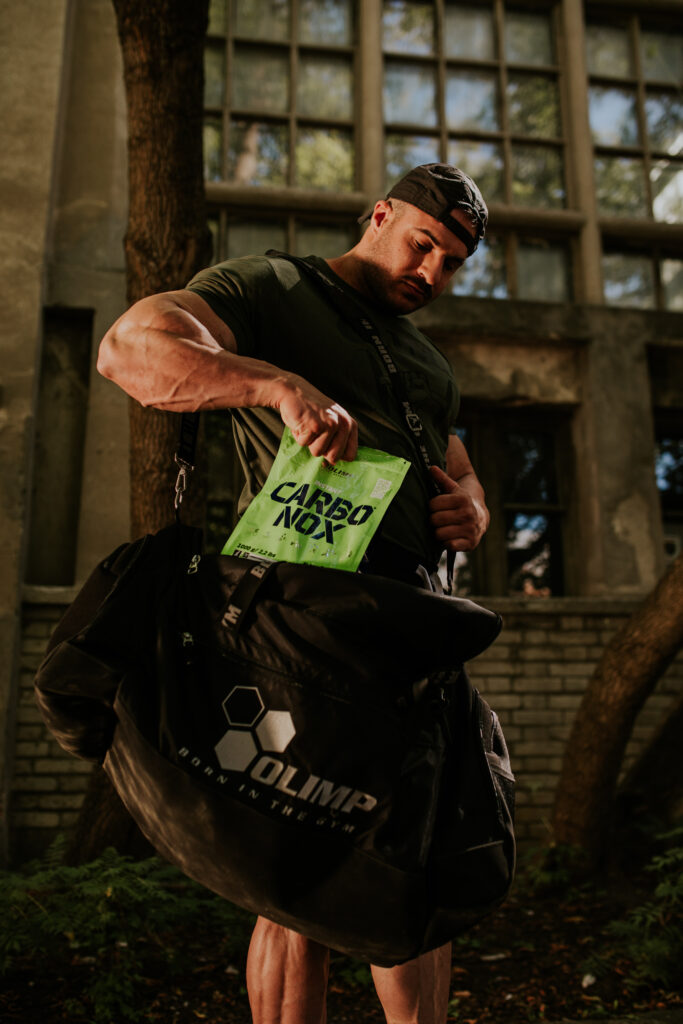 A man taking Olimp Sport Nutrition Carbo Nox out of a bag